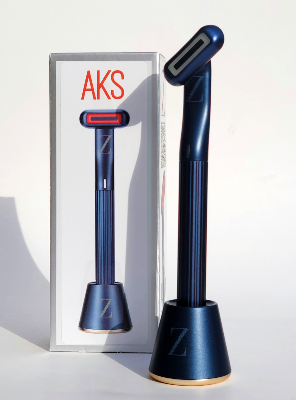 A blue aks otoscope, one of the essential skincare tools, standing next to its packaging box on a white background.