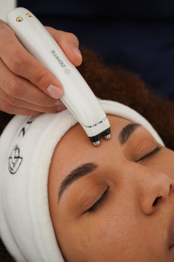 A person receiving a facial treatment with celltite mocrocurrent device